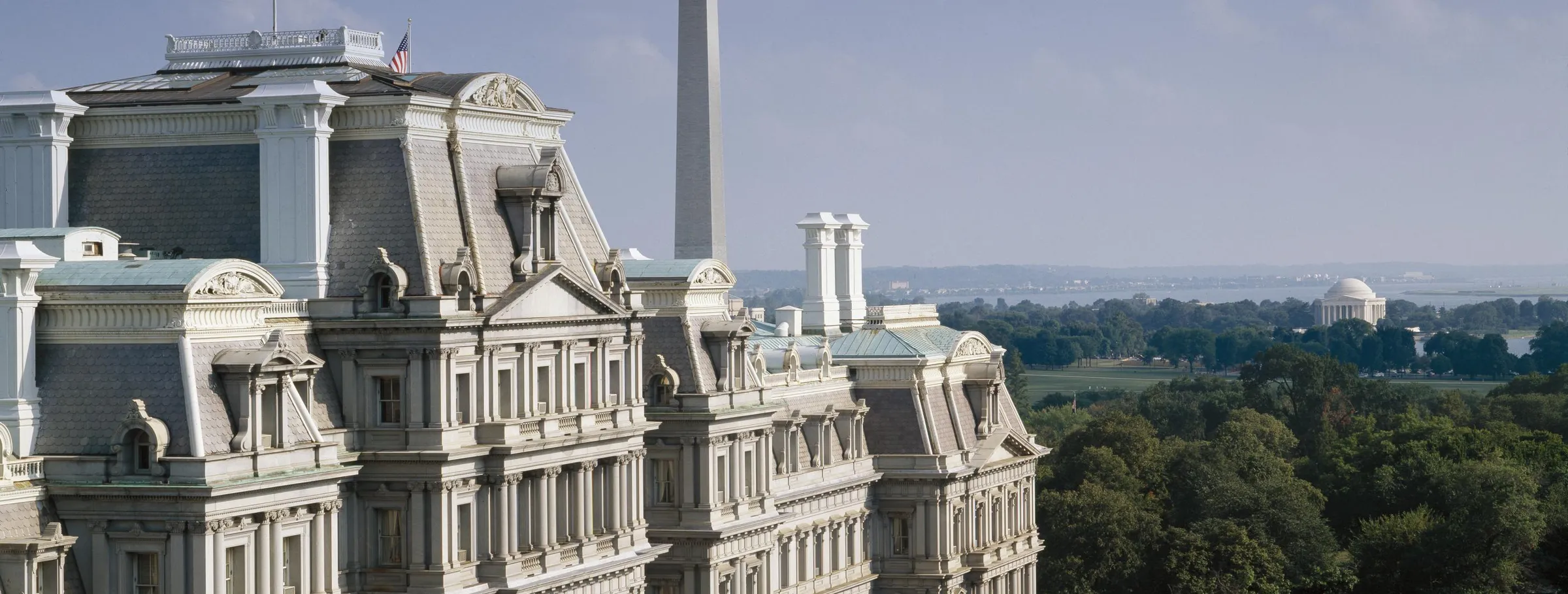 The mansard roofs and chimneys of the Eisenhower Executive Office Building, with the Washington Monument behind.